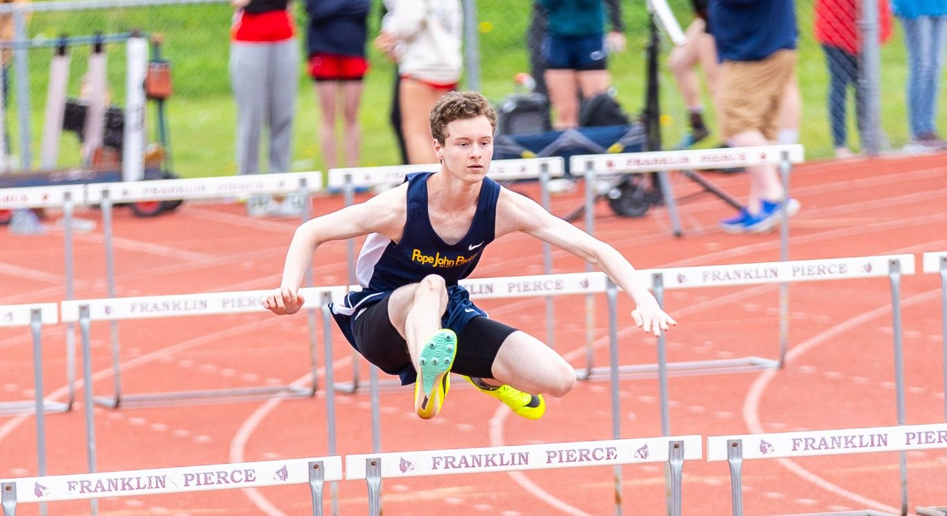 A track & field athlete competing in hurdles.