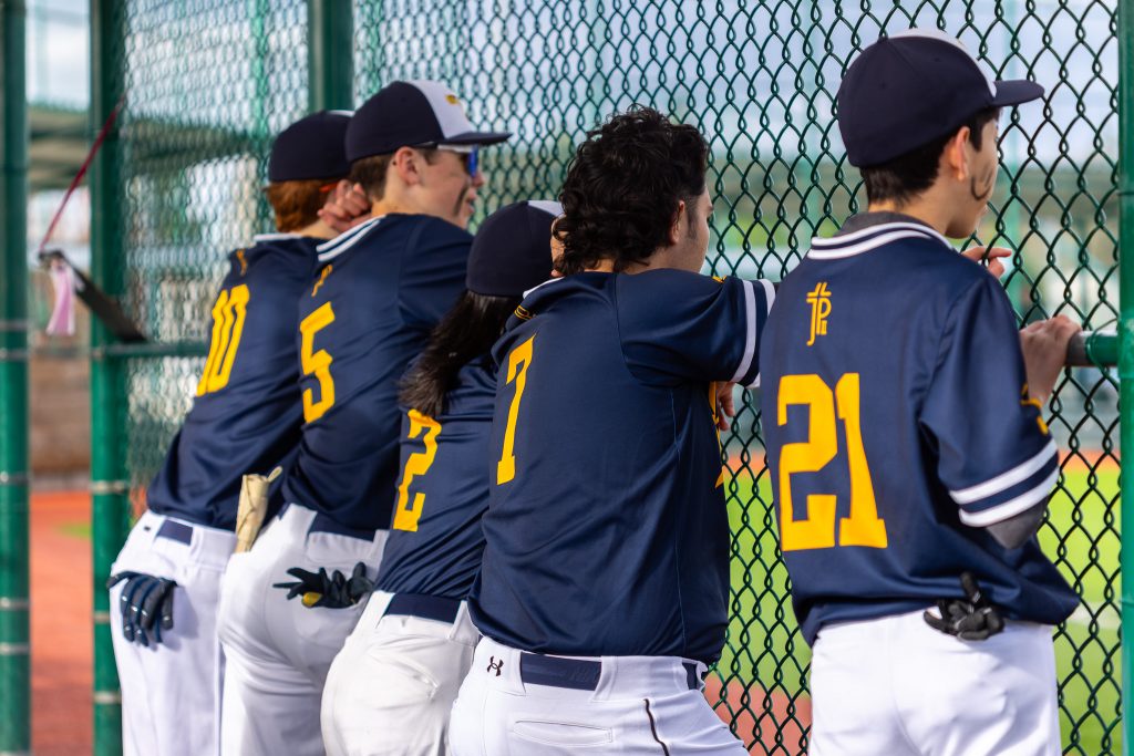 Baseball players lined up in the dugout.
